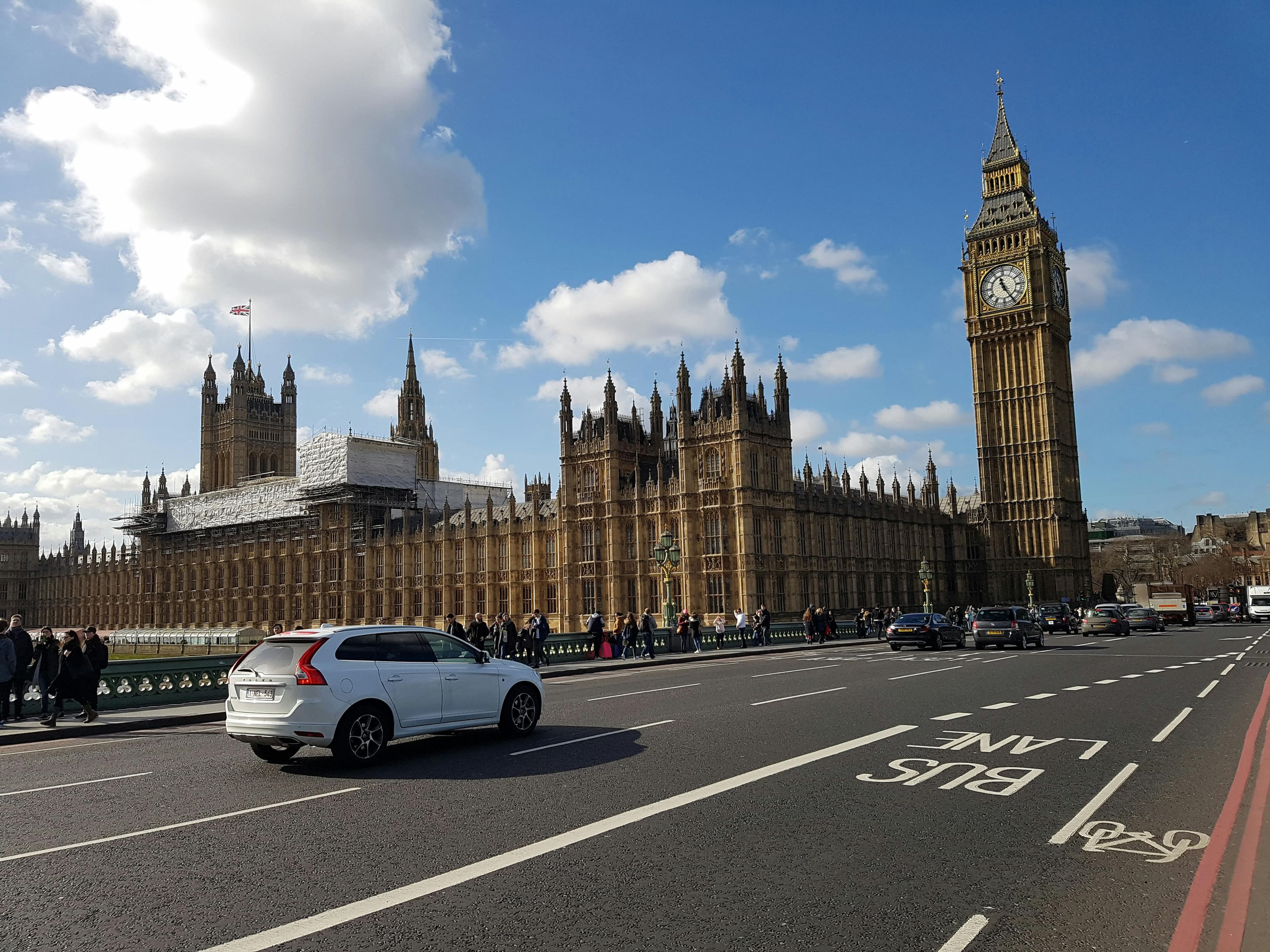 Car driving by Big Ben and the Houses of Parliament in Westminster, London
