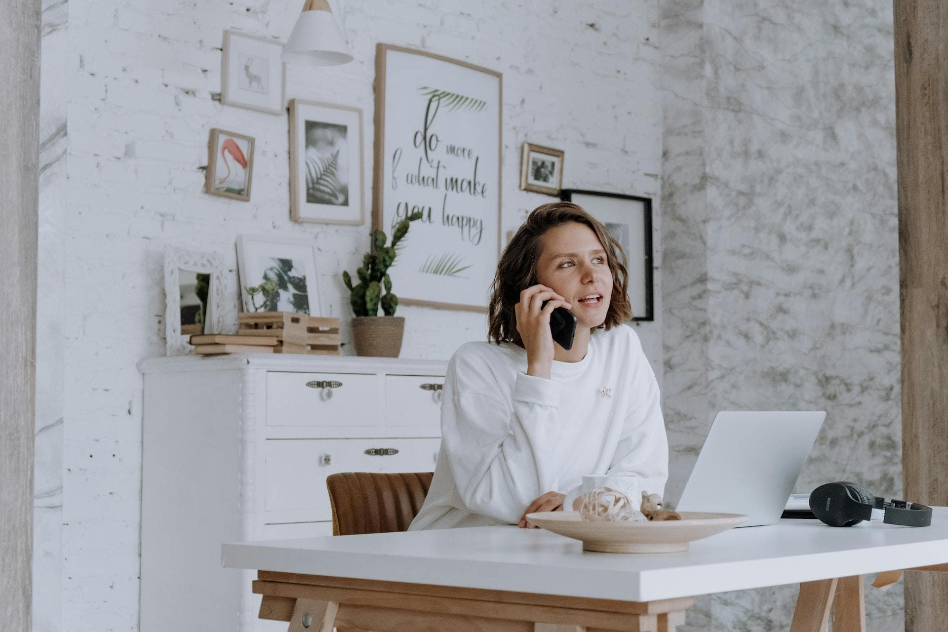 Woman in white shirt in white office talking on the phone