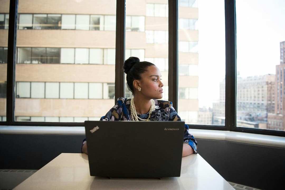 Woman sitting in front of a black laptop