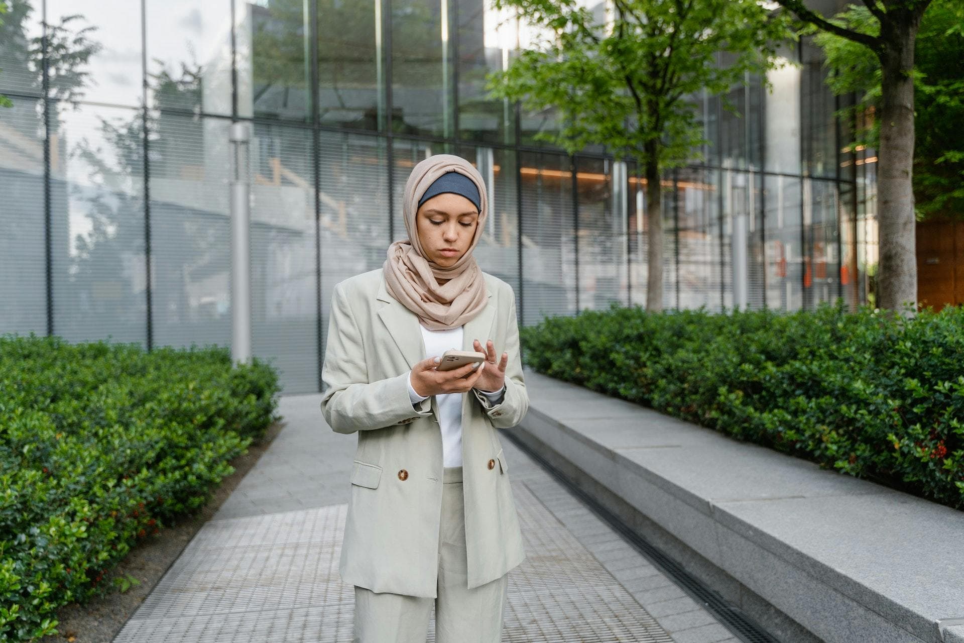 Woman wearing a hijab on phone outside building | I can’t pay my Corporation Tax bill. What can I do?