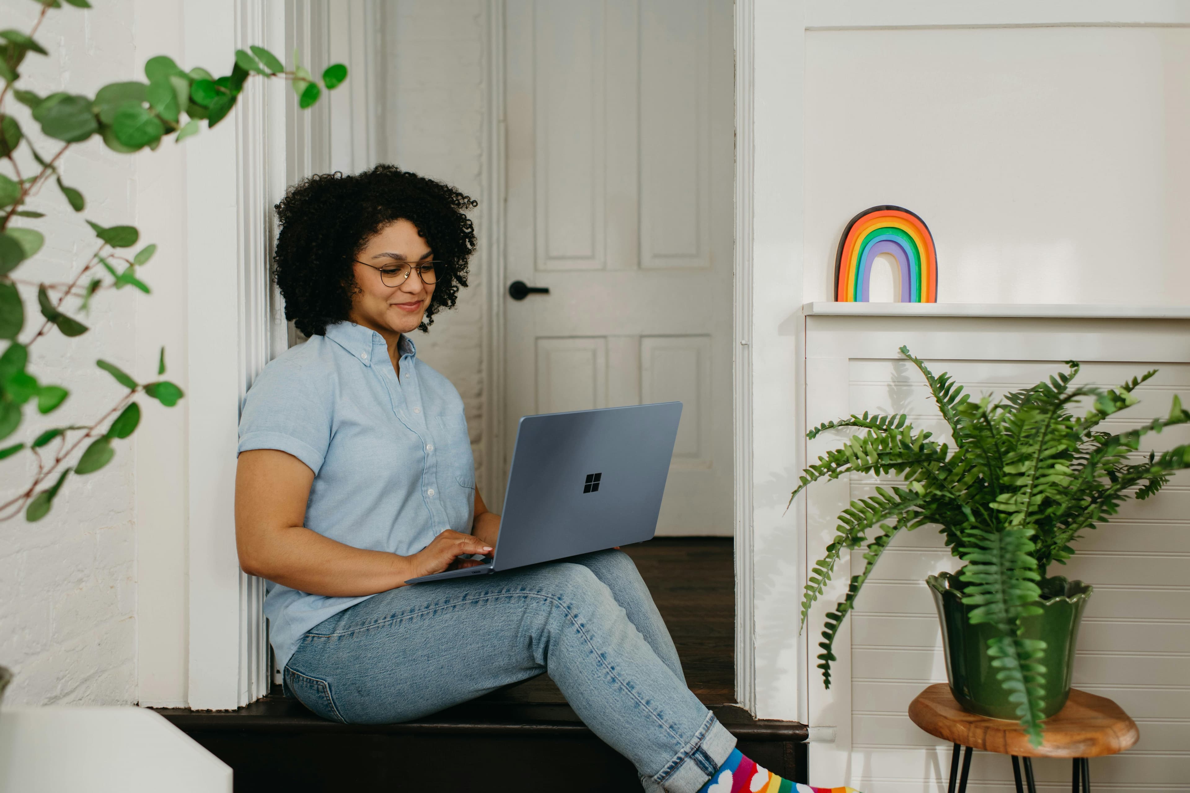 Freelancer on laptop next to rainbow drawing