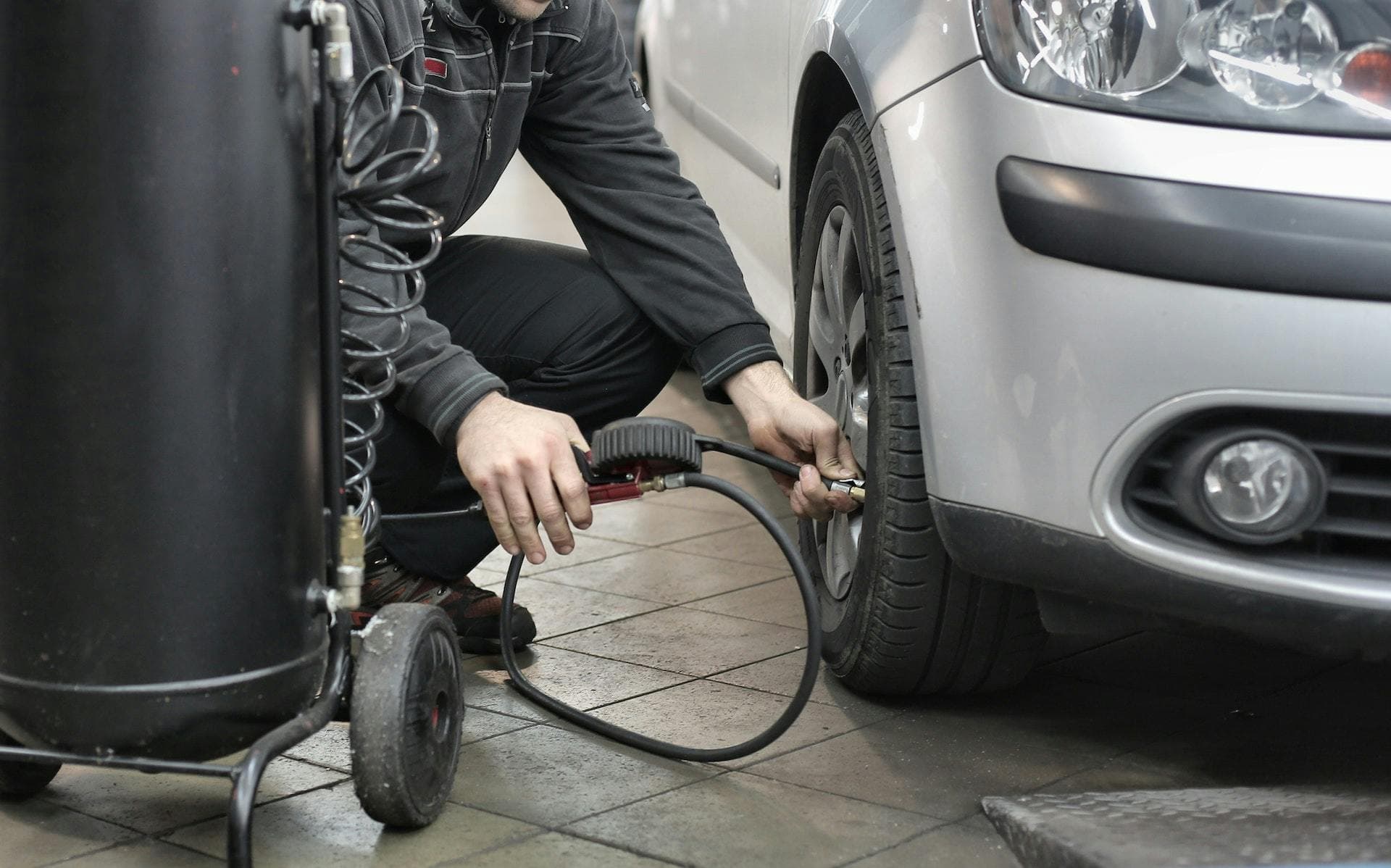 Mechanic pumping up a car tyre | Depreciation: What it means and how to calculate it