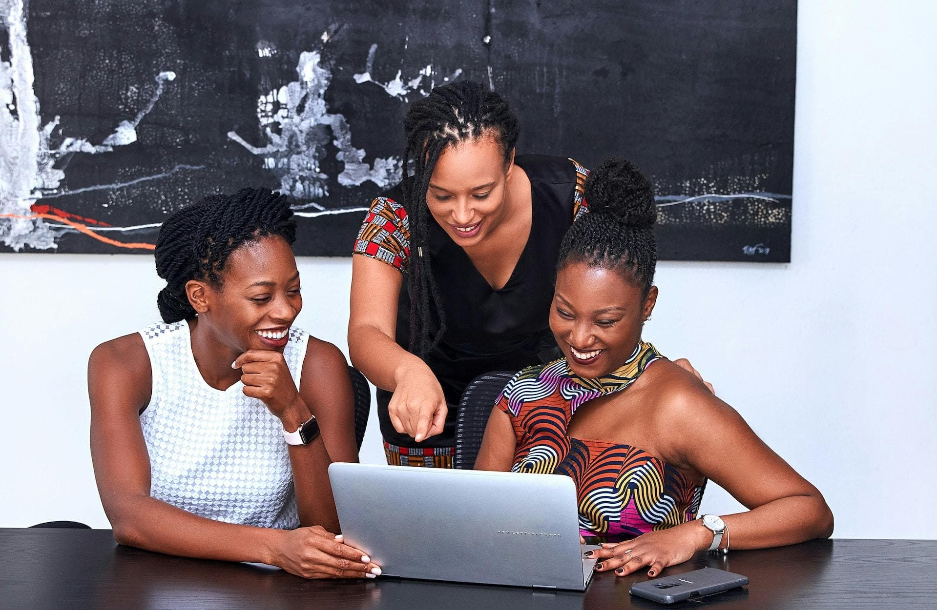 Three female entrepreneurs looking at a laptop