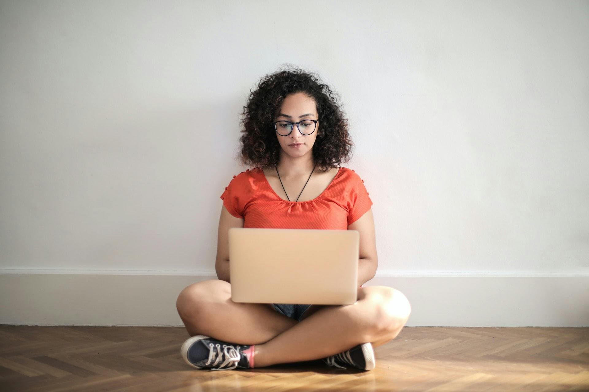 Freelancer on laptop sitting cross-legged on floor