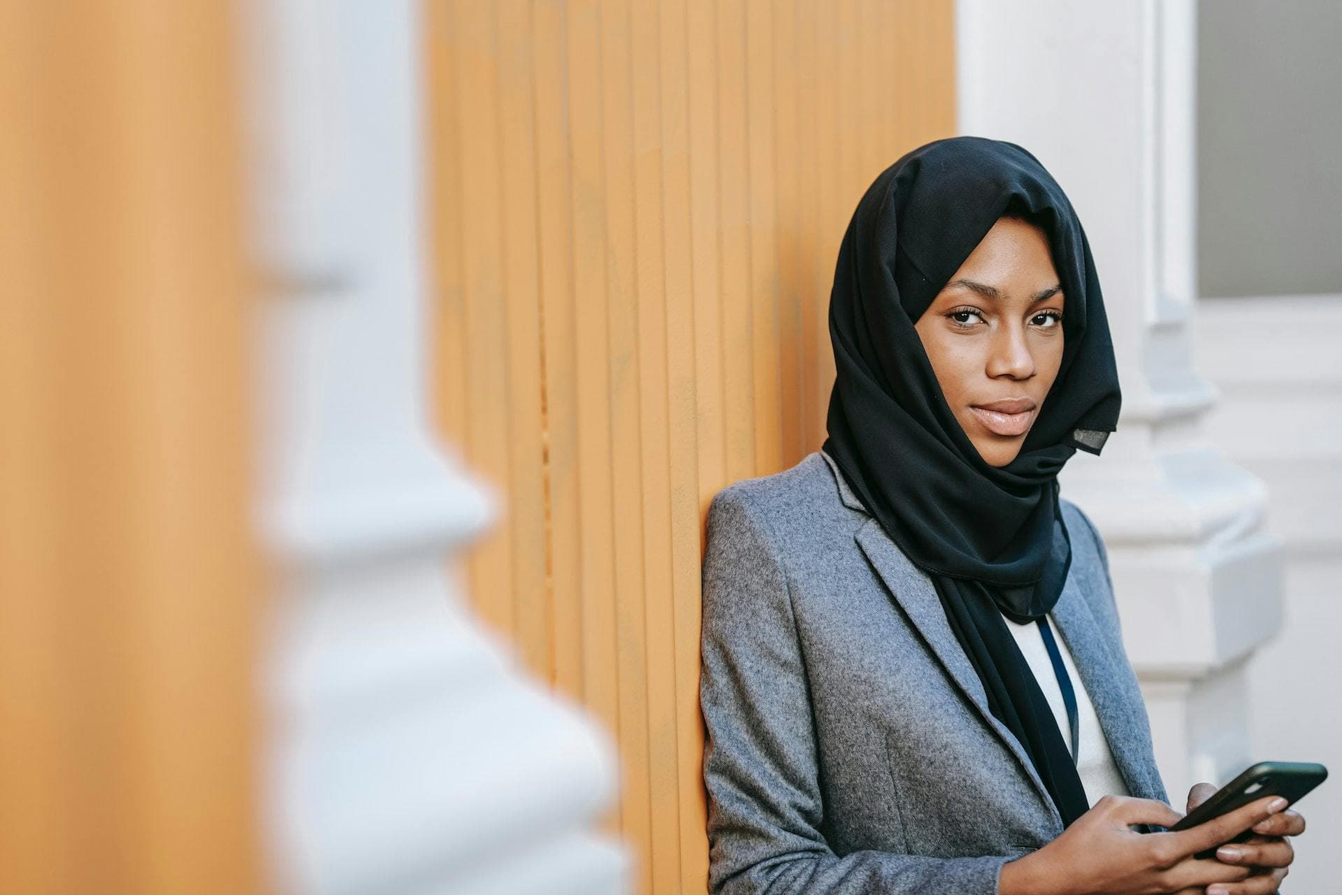 Business owner in black hijab holding a mobile phone